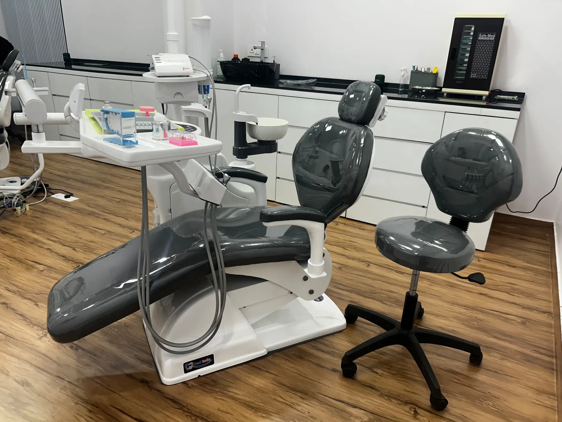Clinical bay with a treatment chair, operator stool and a UV sterilisation chamber for instruments
